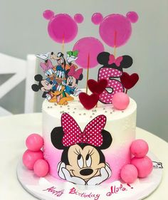 a birthday cake with minnie mouse decorations on it