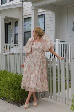 Expertly crafted with a peachy floral chiffon fabric, this midi dress features delicate puff sleeves, a smocked back zipper, and tiered design. Perfect for any occasion, this dress combines style and comfort for a flawless look. peachy floral print chiffon midi length puff sleeves square neckline smocked bodice back zipper closure true to size hand wash cold model is wearing a small and model is 5'5" Billowy Midi Dress For Spring Garden Party, Feminine Flowy Floral Dress With Puff Sleeves, Billowy Feminine Dress For Garden Party, Spring Brunch Midi Dress With Billowy Fit, Spring Midi Dress With Gathered Neckline For Garden Party, Flowy Puff Sleeve Dress For Garden Party, Spring Garden Party Midi Dress With Gathered Neckline, Flowy Midi Dress With Smocked Back For Garden Party, Flowy Puff Sleeve Midi Dress With Floral Print