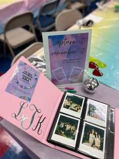 a table topped with pictures and photos next to a pink book on top of a table