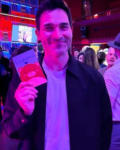 a man holding up a card with a bear on it in front of a crowd