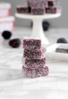 several pieces of cake sitting on top of a white plate next to raspberries