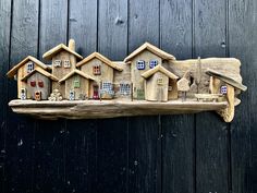 a group of wooden houses sitting on top of a piece of wood