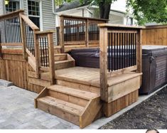 a wooden deck with hot tub and stairs