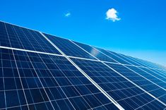 the sun shines brightly on solar panels in front of a blue sky with white clouds