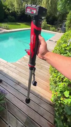 a person holding a drill in front of a pool