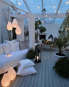 a white couch sitting on top of a wooden floor next to a table with candles