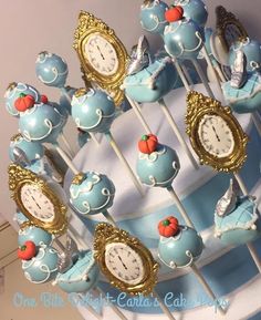 there are many blue and gold clocks on top of cake popss that look like they were made out of fondant