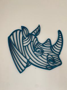 a rhino head cut out of metal on a white surface with blue lines around it