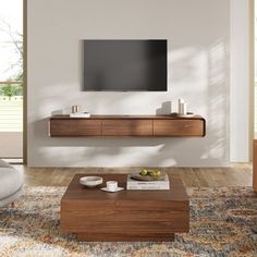 a living room with a large flat screen tv mounted on the wall above a wooden coffee table