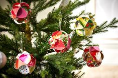 an ornament is hanging on the christmas tree's branch, which has been decorated with different colors and shapes