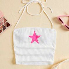 a white bag with pink star on it next to eyeglasses and other items