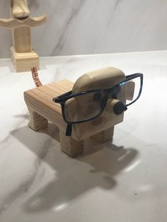 a pair of glasses sitting on top of a wooden bench next to a mannequin