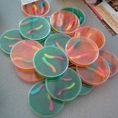 several plastic cups with toothbrushes in them sitting on a table next to books