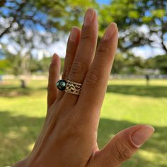 Stun with this classic Hawaiian Heirloom scrollwork ring with a sparkling diamond band and a gorgeous Tahitian black pearl at its crown. Crafted locally in Hawaiʻi, this piece represents "Everlasting Love." Perfect for anniversaries, engagements, or that special occasion. "Hawaiian Heirloom Scroll" Design Ring 14K Yellow Gold 10mm Tahitian Black Pearl (Black, Green, Grey and Peacock Overtones) Natural Diamond: 0.216 CTW 10mm Wide Band Contact us for additional ring sizes Locally Made in Hawaiʻi Black Pearl Ring, Tahitian Black Pearls, Everlasting Love, Wide Bands, Black Pearl, Tahiti, Pearl Ring, Sparkle Diamonds, Diamond Bands