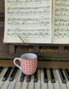 a coffee cup sitting on top of a piano