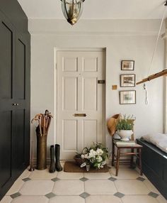 a hallway with black and white tile flooring and pictures on the wall above it