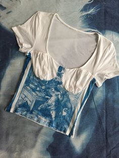 a blue and white tie dye t - shirt on a bed