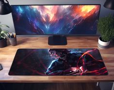 a desk with a computer monitor, keyboard and mouse pad on it next to a potted plant