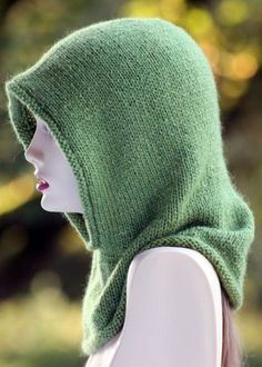 a mannequin head wearing a green knitted hat with a hood on it