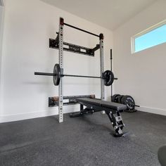 a home gym with two squat racks and one bench