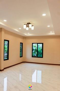 an empty room with three windows and white marble flooring in front of two large windows