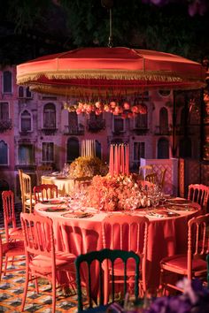 an outdoor dining area with tables, chairs and umbrellas in the middle of it