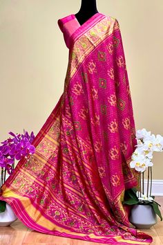 This beautiful single ikkat Patola saree in pink color is woven in narikunj design. The borders are woven in antique gold tissue with the ikkat design, and the pallu has a beautiful floral patterns. Approximate Length 6.5 mtrs (inclusive of blouse length)Height - 46 - 50" Saree comes with fall, picot and tassels done. Blouse piece is cut. Approximate weight - 1.2 lbs Kindly Note : The colors you see on your device may vary due to the color reproduction, brightness and resolution of individual devices. If you'd like more clarity before your purchase, please contact our support team. Pink Slub Silk Dupatta For Transitional Season, Pink Bandhani Print Pre-draped Saree For Festivals, Pink Slub Silk Pre-draped Saree With Dupatta, Pink Bandhani Print Chanderi Pre-draped Saree, Pink Bandhani Print Pre-draped Chanderi Saree, Festive Pink Bandhani Print Pre-draped Saree, Pink Bandhani Print Pre-draped Saree For Diwali, Transitional Art Silk Saree With Ikat Print, Festive Tussar Silk Dupatta With Ikat Print