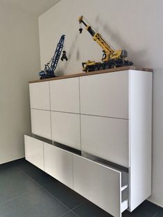 a crane is on top of a white cabinet