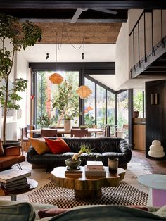 a living room filled with lots of furniture and plants on top of it's tables