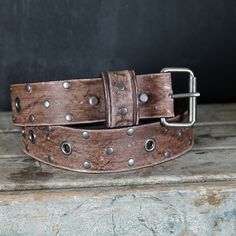 Grommets and studs leather belt, aged.  . Our Aging / Relic process is carefully made by Hand, from the leather to the Hardware, giving this unique Strap Authenticity and the Style we love like it  already lived for decades.  Features: Designed with Chicago screws that allows you to easily remove and replace the Buckle.  .Leather: 7-8oz (4-5 mm thick) premium vegetable tan leather, great thickness for durability and comfort that will age beautifully with time.      .Width : 2 inches wide. .Color: Aged light Brown . hand dyed with a rich Finish  .Hardware and studs: Antique Nickel. .Size:     -PLEASE CHOOSE YOUR SIZE VERY CAREFULLY -- .Our recommendation and most accurate way to Choose your size as shown in the Picture.  Our mission is for you to pick the correct size and enjoy your new bel Artisan Leather Belt Buckle With Antique Design, Adjustable Rustic Leather Belt Buckles, Rustic Distressed Brown Belt Buckle With Antique Design, Rustic Distressed Brown Leather Belt Buckles, Rugged Distressed Brown Belt Buckle With Antique Buckle, Rugged Leather Belt Buckles In Distressed Brown, Rustic Vintage Brown Leather Belt Buckles, Rustic Adjustable Leather Belt, Adjustable Leather Belt Buckles With Rivets