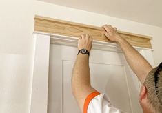 a man is working on a door frame