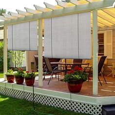 a covered patio with potted plants on the side and an awning over it