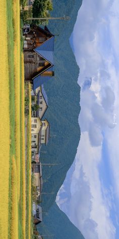 an aerial view of a house on the edge of a body of water with mountains in the background