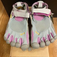 a pair of gray and pink shoes sitting on top of a box