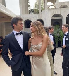 two people standing next to each other in formal wear and tuxedo's