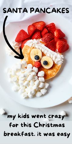 a white plate topped with fruit and marshmallows next to a santa pancake