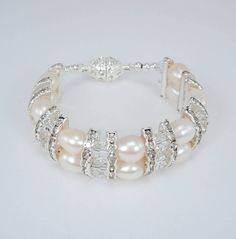 This bracelet is beautiful and has lots of crystal sparkle.  Double row if genuine creamy white 8 and 9mm freshwater pearls, 9mm clear round faceted Swarovski crystals, silver tone rhinestone crystal spacers, sterling silver beads and a beautiful 11mm x 16mm clear crystal magnetic clasp. There are two bracelet lengths to choose from 6.5 inch and 7.5 inch and I have one of each size.  Choose length from drop down. The crystal sparkle is amazing and would make a beautiful bridal bracelet.  A very Elegant Silver Crystal Bracelet With Pearl Charm, White Crystal Pearl Bracelet For Formal Occasions, Elegant White Crystal Pearl Bracelet, Formal White Crystal Pearl Bracelet, Silver Crystal Bracelet With Pearl Charm, Silver Pearl Charm Crystal Bracelet, Beaded Pearl Bracelet For Anniversary, Elegant Pearl Crystal Bracelet With Round Beads, Adjustable White Crystal Pearl Bracelet