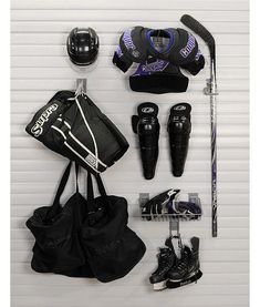 a hockey uniform and equipment are arranged on a wall next to the goalie's helmet