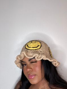 a woman wearing a hat with a smiley face on it