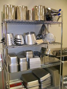 a metal shelf filled with lots of silver items