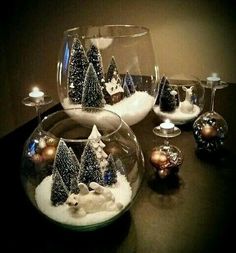 there are several glass vases with christmas trees in them and snow on the ground