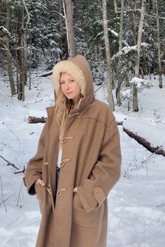 "Warm and cozy 60's - 70's hooded wool blanket coat with pockets and braided rope + wooden toggle buttons. Big and heavy, sure to keep you warm!! This coat is in good vintage condition - there are a few small little moth bites. Sizing + Measurements: Fits like a women's XL - XXL / Oversized Bust: 58\" Sleeve: 25\" Shoulders: 20\" Overall Length: 39\" For reference, model is 5'9\" 34/29/40 All measurements are taken flat and then doubled when appropriate. Please let us know if you have any questi Hooded Wool Outerwear With Pockets, Hooded Brown Outerwear With Buttons, Brown Hooded Outerwear With Buttons, Wool Outerwear With Detachable Hood For Cold Weather, Brown Parka With Adjustable Hood For Cold Weather, Vintage Winter Pea Coat With Pockets, Brown Hooded Wool Coat For Winter, Wool Hooded Outerwear With Drawstring, Hooded Wool Winter Outerwear