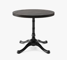 a round wooden table with an iron base