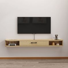 a flat screen tv mounted to the side of a wooden shelf in front of a white wall