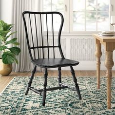 a green chair sitting on top of a rug next to a table with a potted plant