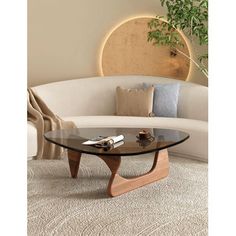 This coffee table draws inspiration from the iconic 1950s design crafted by the renowned poet and sculptor, Isamu. The classic smooth curves are a testament to Isamu's defiance of conventional straight lines, embodying a sense of artistic rebellion. Our reproduction captures the essence of elegance and simplicity that this coffee table is celebrated for, making it a fitting addition to any contemporary home or workspace. Wrought Studio™ Table Base Color: Walnut | Wrought Studio™ Holderman Glass Irregular Coffee Table, Coffee Table Small Space, Nyc Dream, Triangle Coffee Table, Modern Wood Coffee Table, Living Room Center, Tafel Decor, Mid Century Modern Coffee Table, Glass End Tables