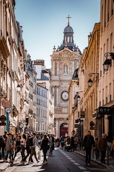 people are walking down the street in an old european city