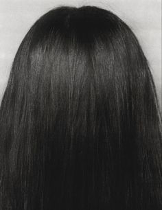 the back of a woman's head with long, straight hair in black and white