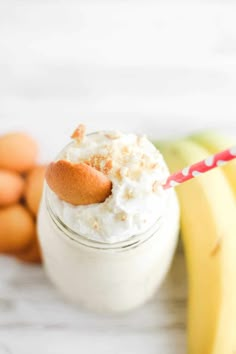 a glass jar filled with whipped cream next to bananas