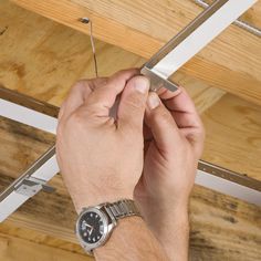 a man is working on the ceiling in his house with two screws attached to it